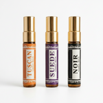 Three perfume bottles labeled 'Tuscan', 'Suede', and 'Noir' on a white background
